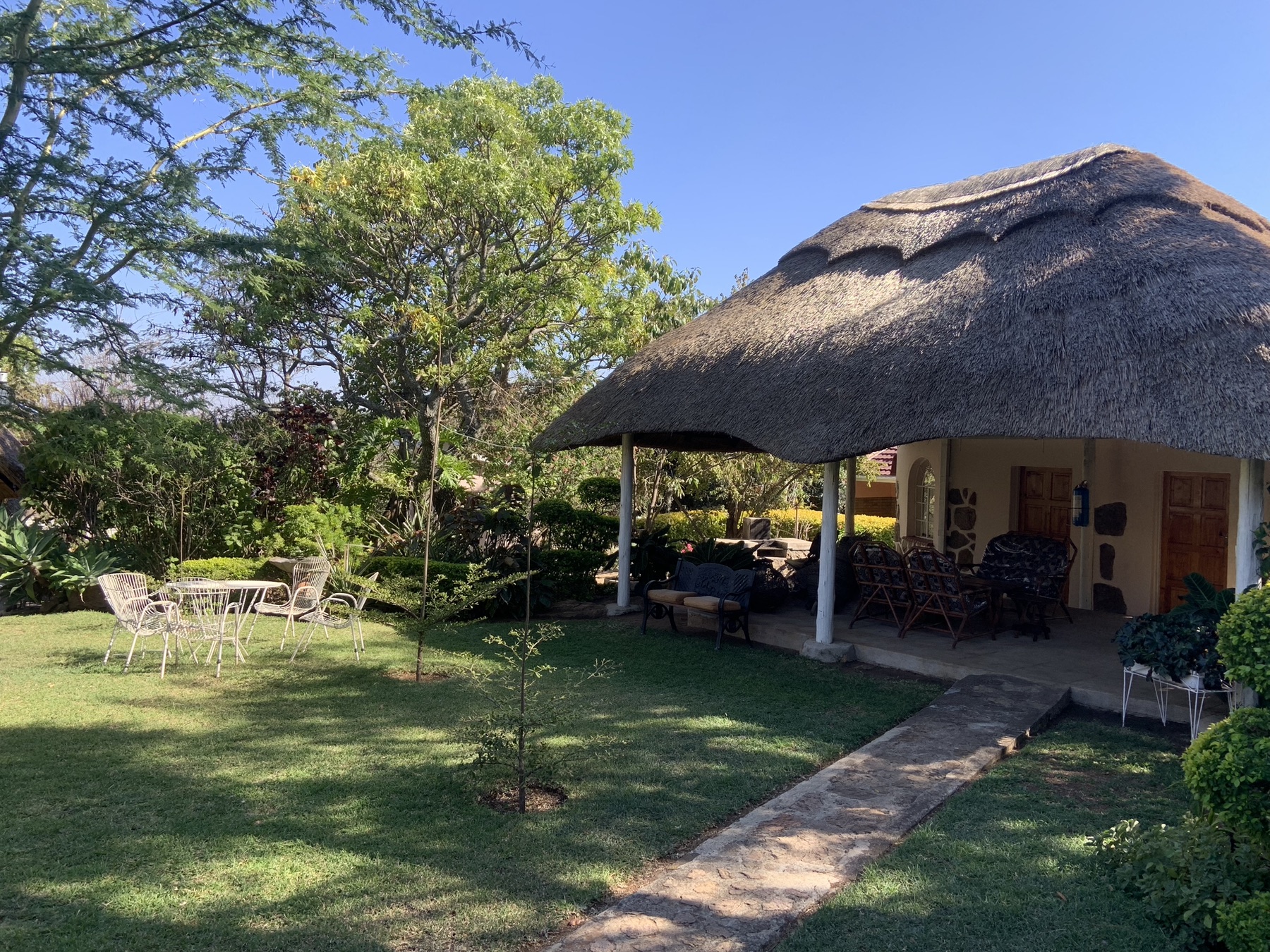 Thatched covered patio and lawn at Lynn's Guesthouse